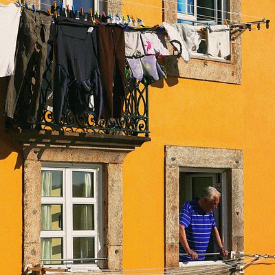 Een man kijkt uit het raam van zijn appartement 