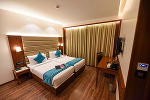 Click Hotel Ayra in Bengaluru, image may contain: Furniture, Bedroom, Indoors, Monitor