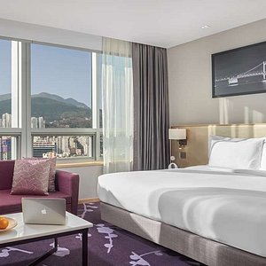 Interior view of Avani Premier Room with king bed and seating area and city view
