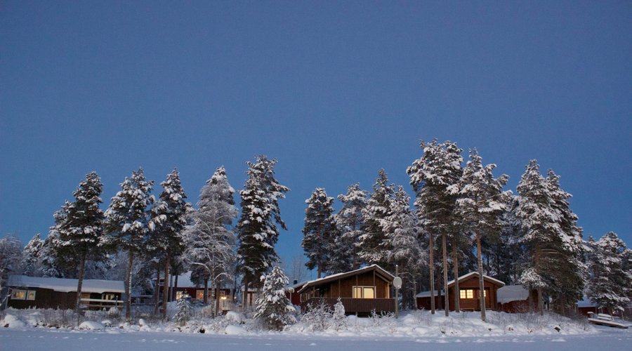 Blue hour view on the lakefront holiday houses at Sandsjögården Holiday Resort.