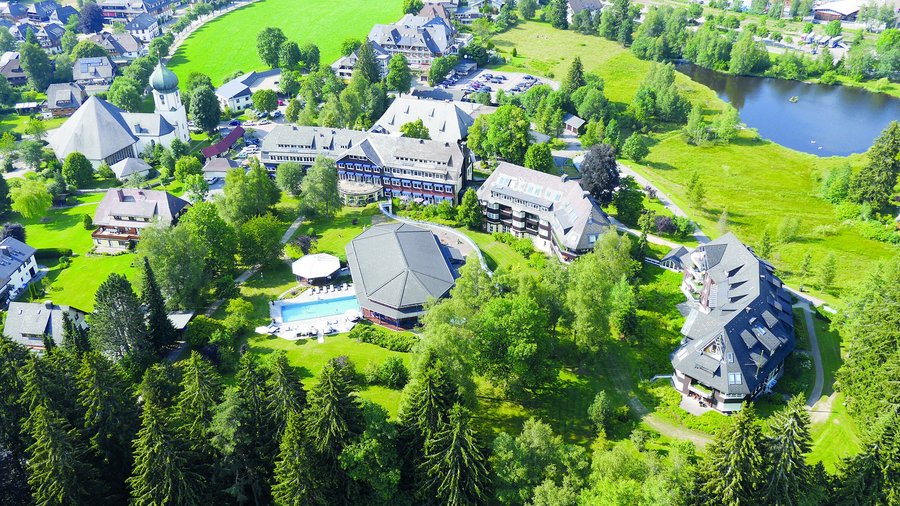 Luftaufnahme mit Park, Gebäuden und kleinem Adlersee auf dem Anwesen von 70.000 Quadratmetern