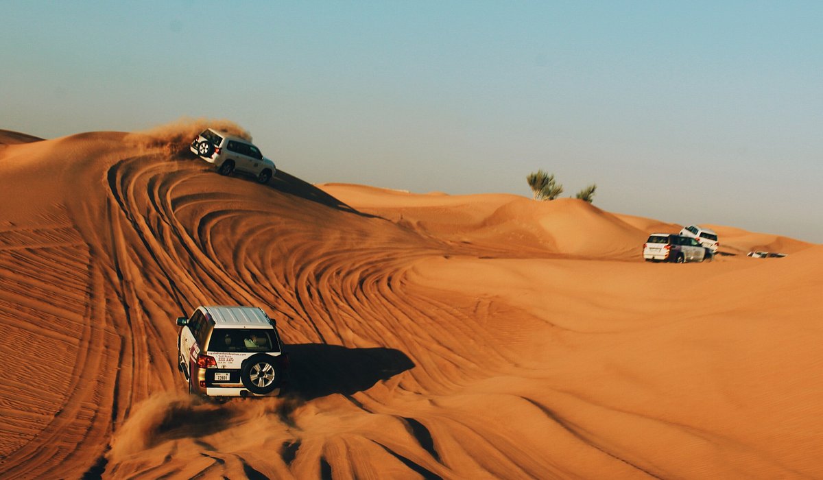 두바이 사막 사파리에서 모래 언덕을 따라 달리는 사륜구동 자동차