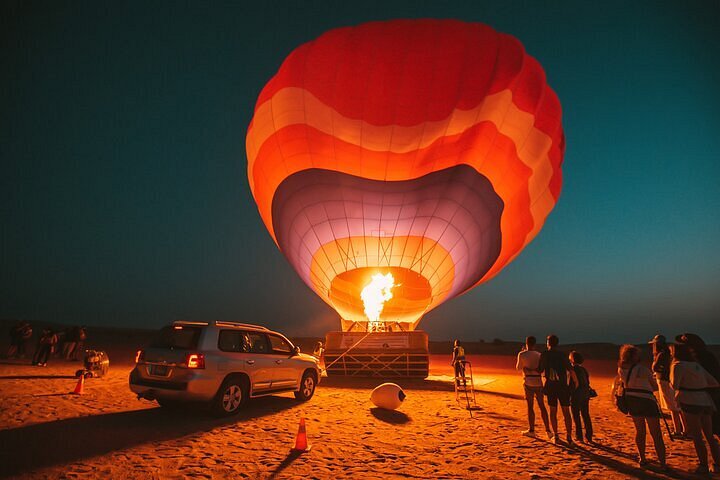 A hot air balloon being fired up on a morning desert safari in Dubai