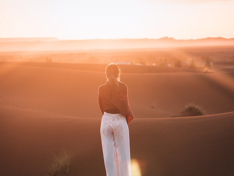 두바이의 사막 모래 언덕에 서 있는 여성