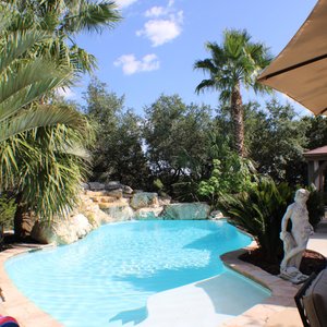 Relax Poolside featuring a natural limestone waterfall. Tons of deck space 5o chill ou5 and a big party cabana with steam room. The pool area is shared between two rental units each hosting a maximum of 2 guests.