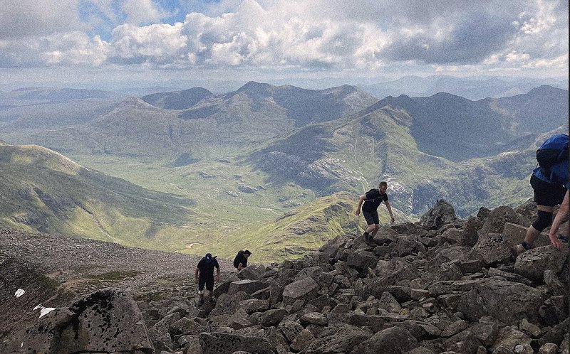 A group of hikers scaling to the summit of Ben Nevis