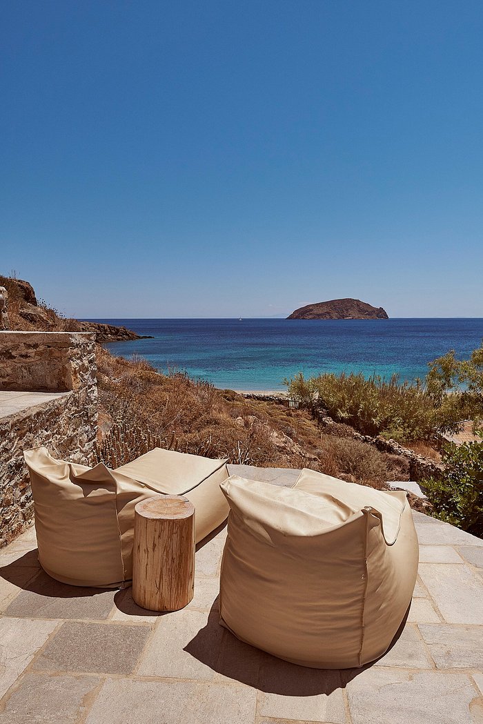 Premium Photo  Brown beanbags and table on white rocks by the sea