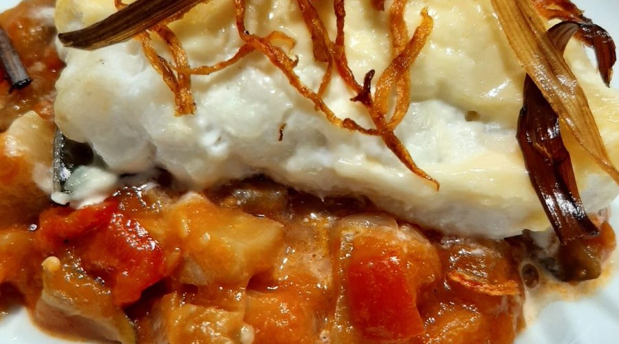 Bacalao al horno gratinado sobre cama de pisto.