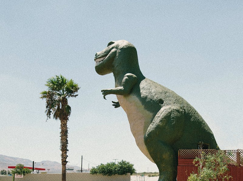 Dinosaur statue on the road
