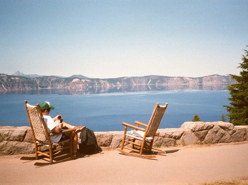 Man sitting in a rocking chair along overlooking water