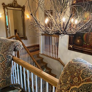 The Willow Reed chandelier greets guests at the top of the entry staircase at The Birdnest Inn!!
