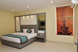 Hotel Tridev Grand in Varanasi, image may contain: Bed, Furniture, Person, Bedroom