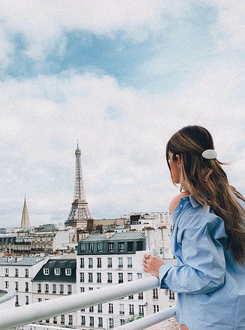 A woman viewing the Eiffel Tower from Citadines Paris hotel