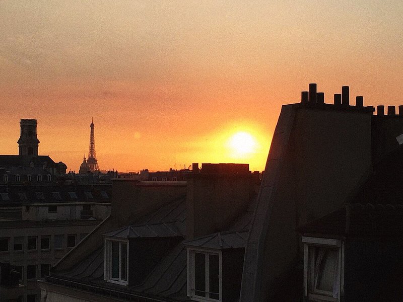 Utsikt over Eiffeltårnet ved solnedgang fra hotellet Le Petit Belloy i Paris