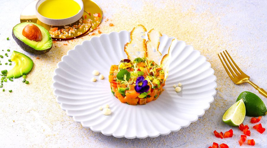 Salmon Tartare with avocado chunks, cherry tomato and red onion, marinated in lime juice, lemon zest and Dijon mustard and enhannced with Greek olive oil, sea salt and freshly ground black pepper.