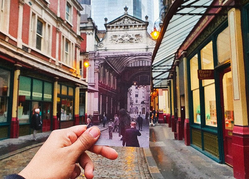 A man holding up a photo of a scene from Harry Potter at Leadenhall Market