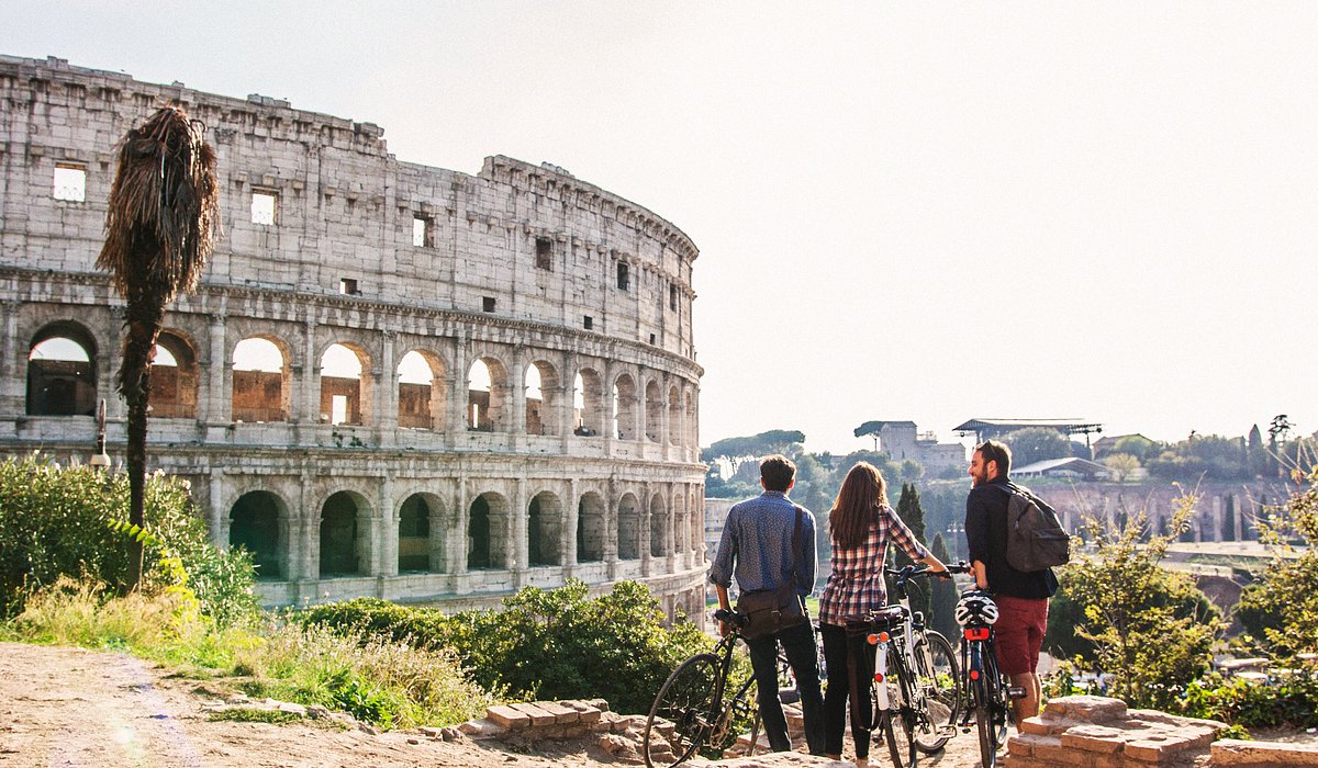 Eine Gruppe von Reisenden, die auf das Kolosseum in Rom blickt