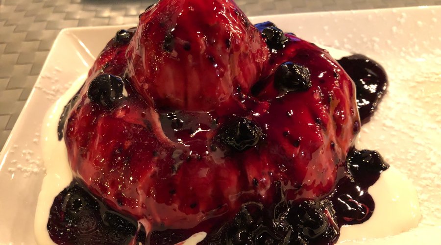 Papanasi ... doughnut drizzled with sour cream and topped with cranberry sauce ....    leave room for it !!! It's so worth it !!!