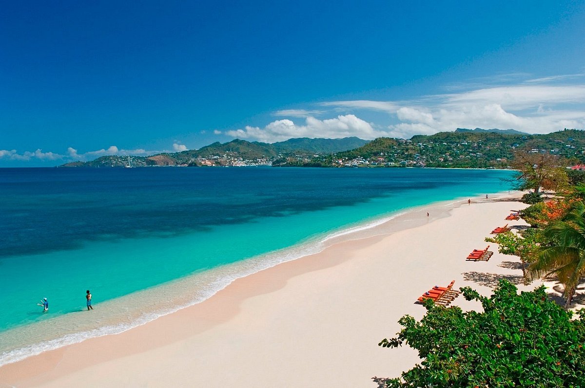 Grand Anse Beach with turquoise waters and green hillsides in the distance