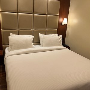 Click Hotel Ayra in Bengaluru, image may contain: Furniture, Bedroom, Indoors, Monitor