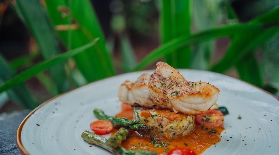 SEABASS FILLET WITH WHITE & GREEN ASPARAGUS: Baked sea bass fillet, Chef Nicolas’ potatoes, zucchini, duo of white and green asparagus, and roasted tomato sauce 