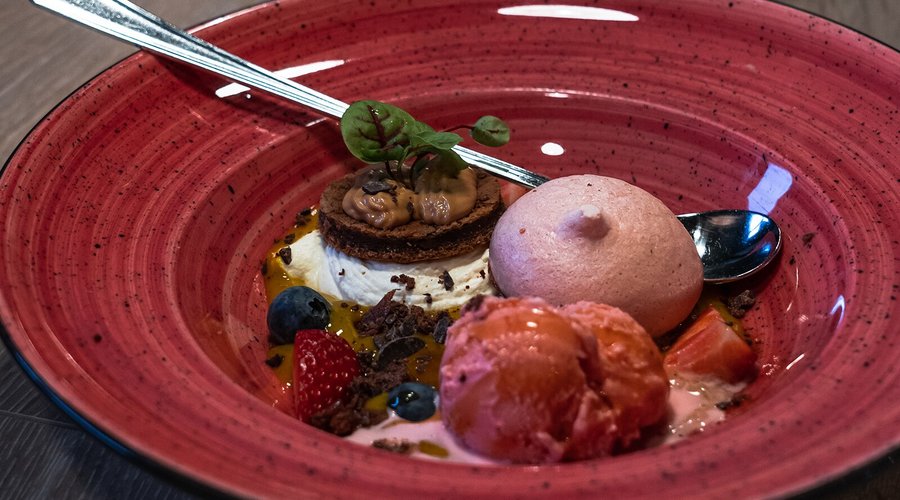 Small homemade brownie served with fresh berries along other tasty goodies