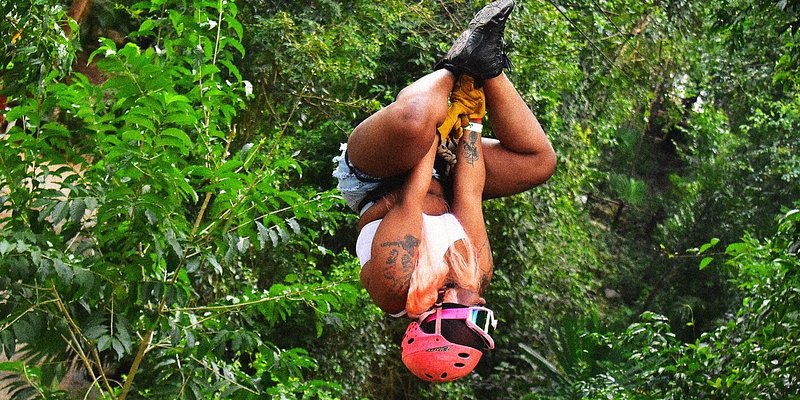 A woman hanging from a zipline in Cancun