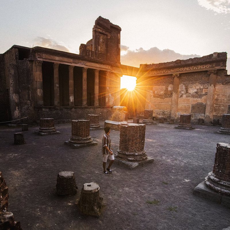 Een man bij de ruïnes van Pompeii bij zonsondergang