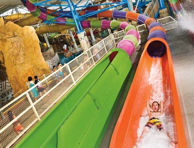 must visit places with family Kid going down colorful waterslide