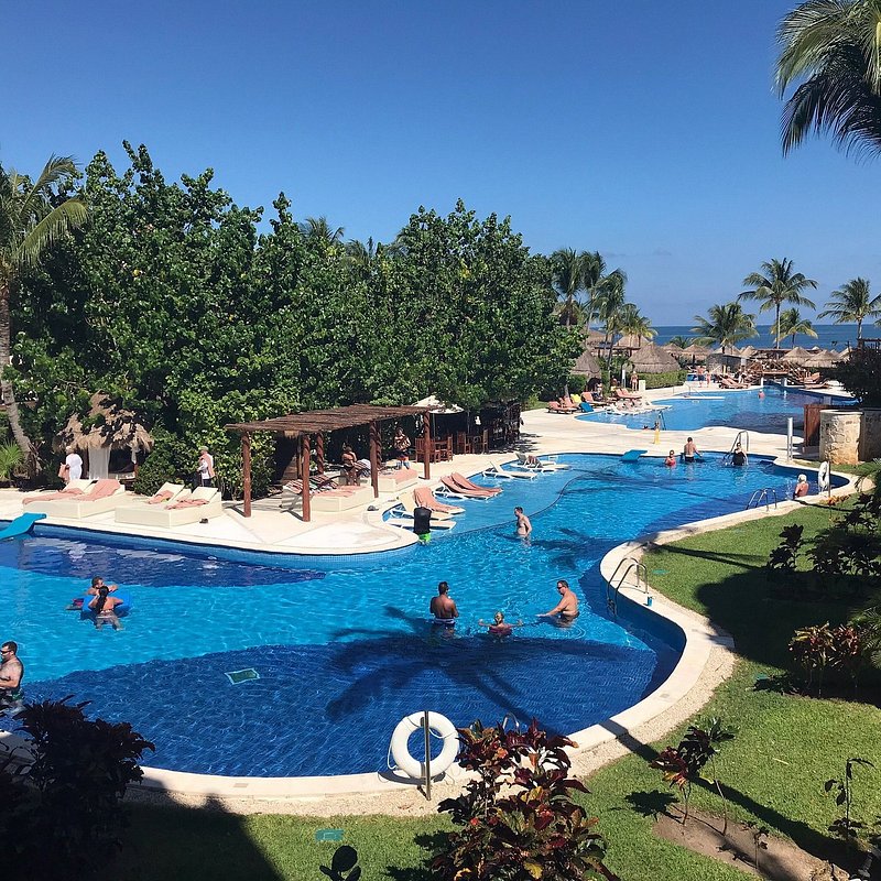People relaxing by the pool in a resort in Puerto Morelos, Mexico
