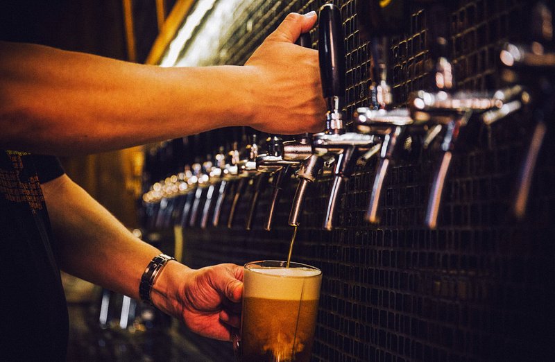 A bartender pouring a pint of craft beer