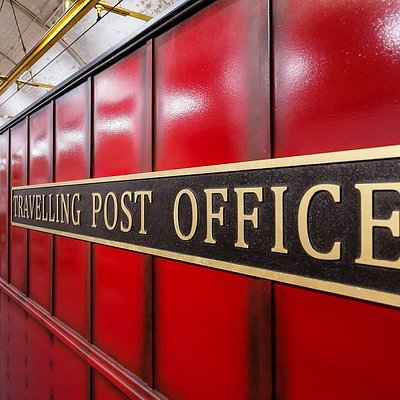 Sign that says travelling post office on a large red container