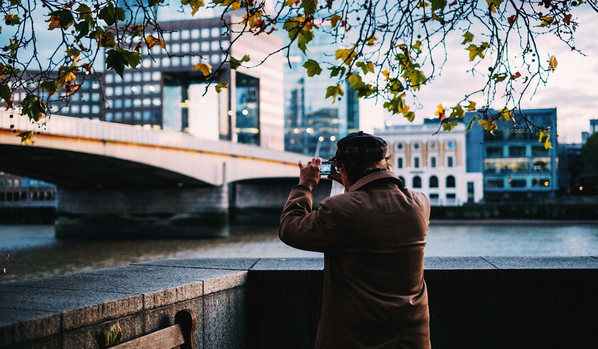 Person taking a photo by the bridge in London