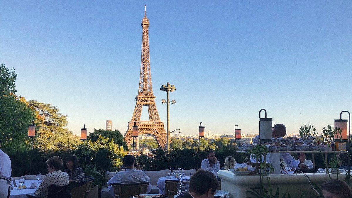 People dining at Girafe restaurant in Paris with view of Eiffel Tower in the background