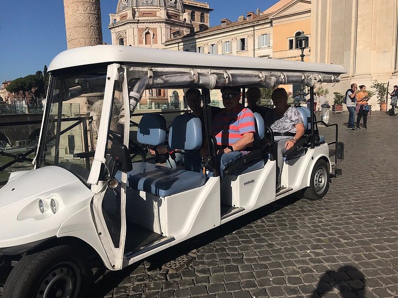 A group of elderly travelers on a golf cart tour of Rome