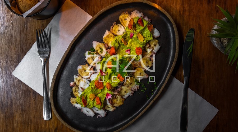 CARPACCIO de PULPO: Pulpo español en láminas, laqueado al ponzu y coronado con emulsión de palta.