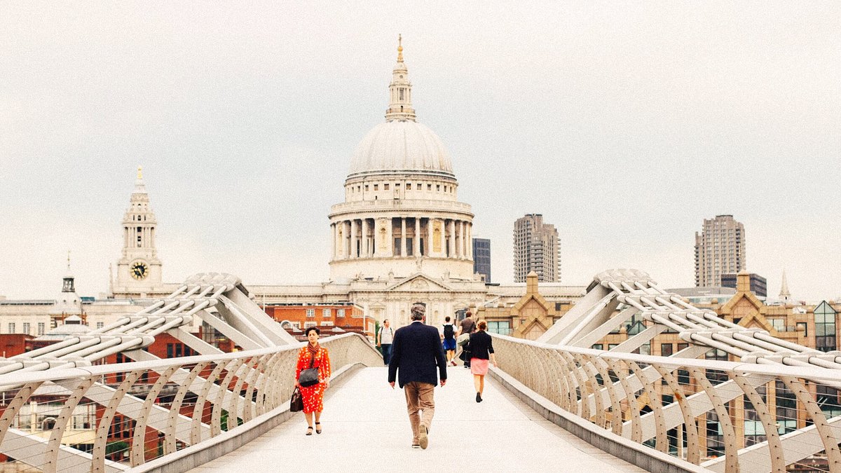 People walking on the Millennium Bridge in London, with St Paul's Cathedral in the background