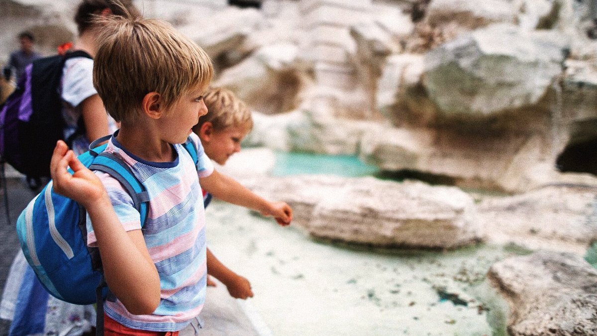 Kids tossing coins into the Trevi Fountain in Rome