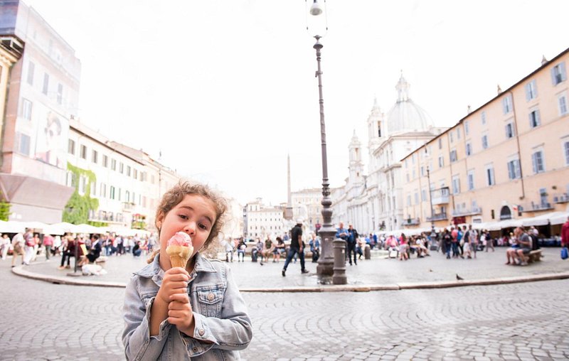 A girl eating a gelato in Piazza Navona square in Rome