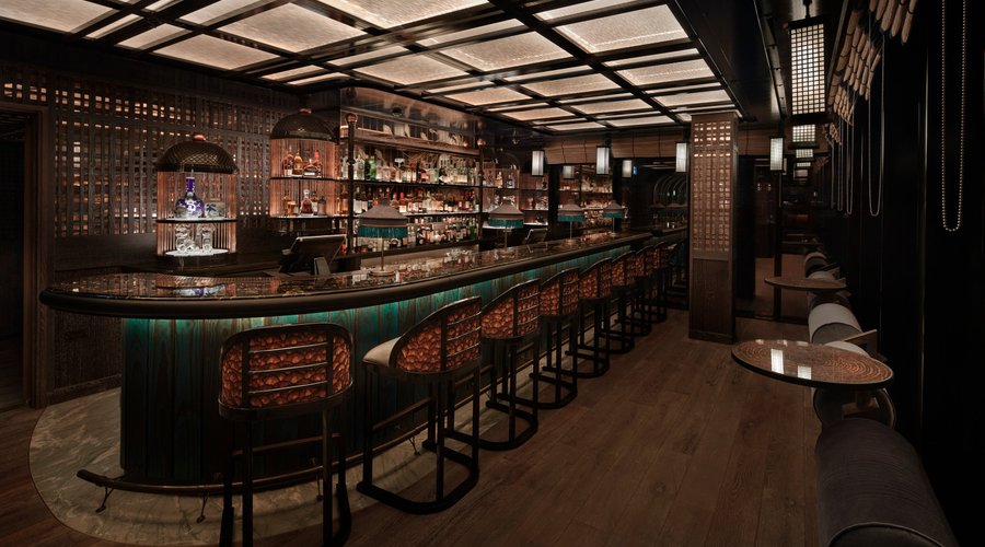 he Flamboyant
Opposite House.

Across the spirit screen, protector of evil and guardian of wealth, our Phoenix inspired bar invites you in with the flicker of a flame. Full of rich, feathered fabrics and charred timbers, with a copper panelled wall that reflects the fiery nature of the firebird to welcome you to Tattu London.