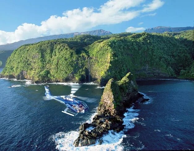 Blue helicopter over Maui coastline