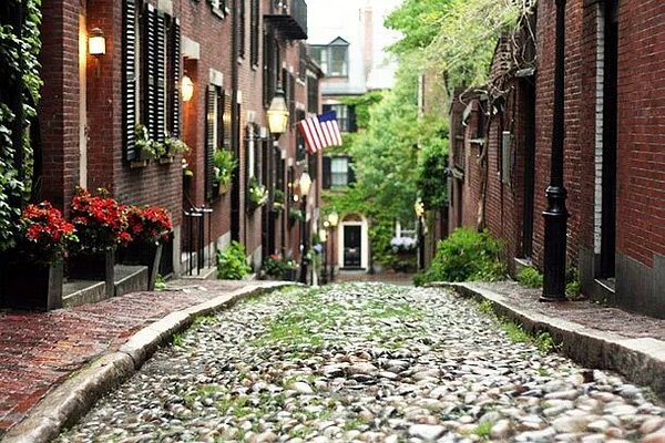 Cobblestone Acorn Street flanked by red brick buildings
