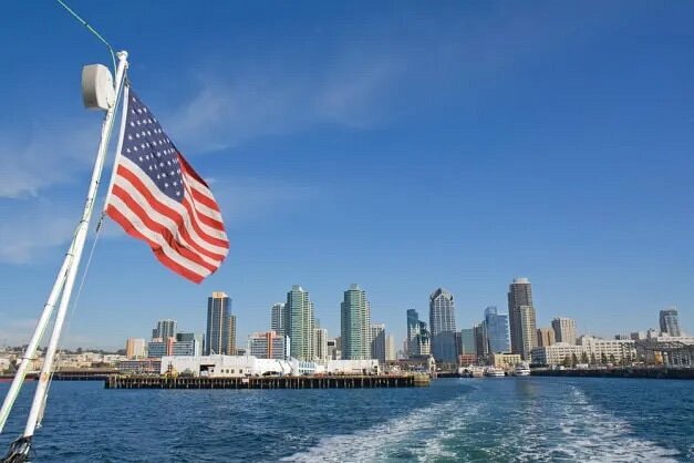 Back of boat with American flag and city in distance