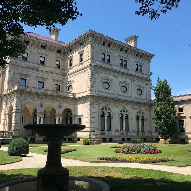 Exterior and surrounding manicured lawn of three-story stone The Breakers
