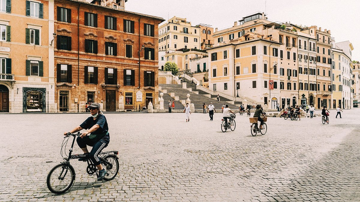 Cyclists in a very quiet Piazza di Spagna in Rome