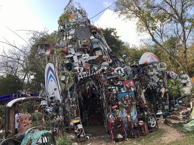 A tower of surfboards, sirens, vents, fans, and whole host of other "trash" forms an entrance walkway