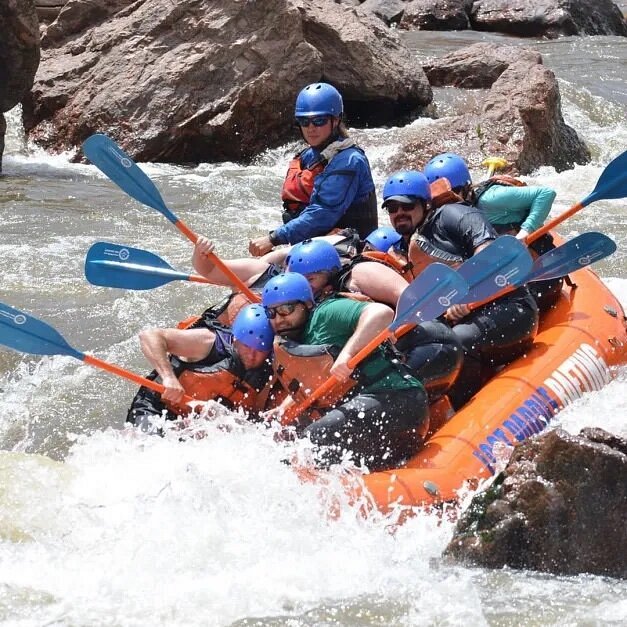 People in raft going over rapid