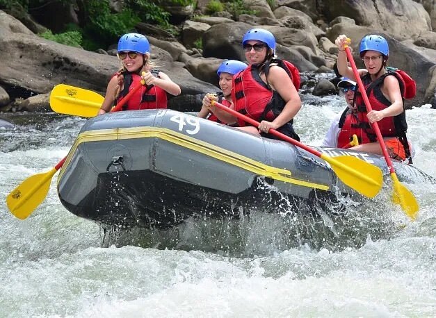 Five people in raft going over rapids