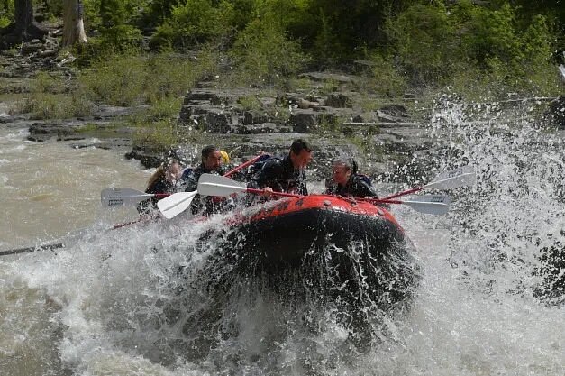 People in raft with water splashing around them