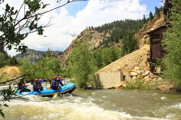 People in blue raft amid green hillsides